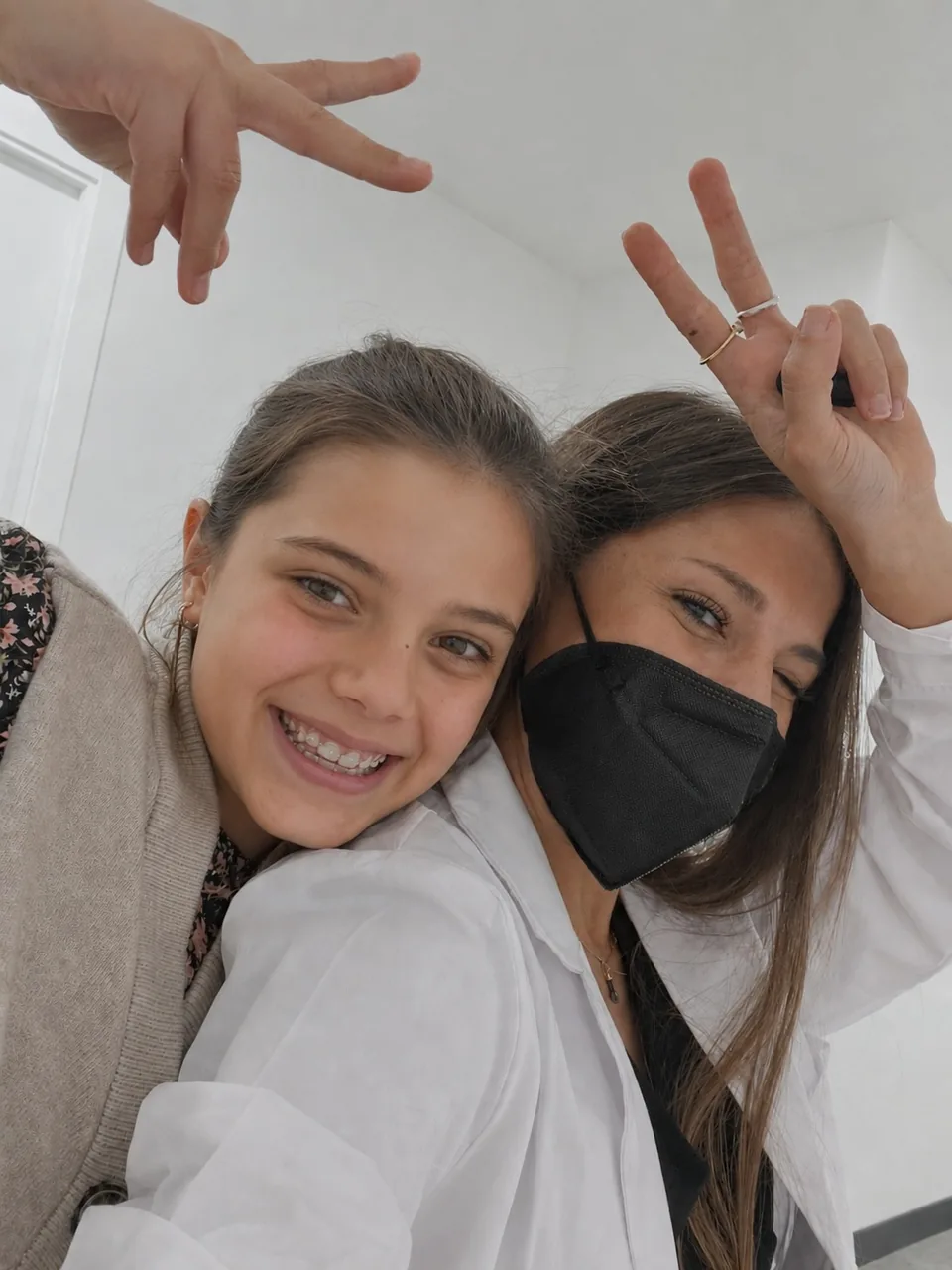 Miembro del equipo de Ortodoncia Santonja y una paciente adolescente sonriendo juntas en la clínica