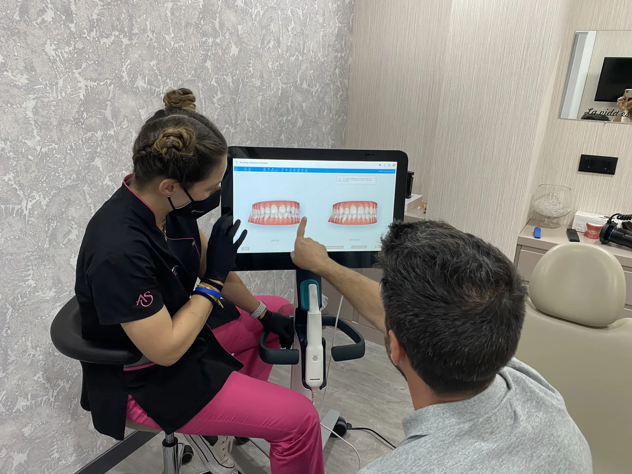 Miembro del equipo de Ortodoncia Santonja mostrando a un paciente la simulación 3D Invisalign de su sonrisa antes y después